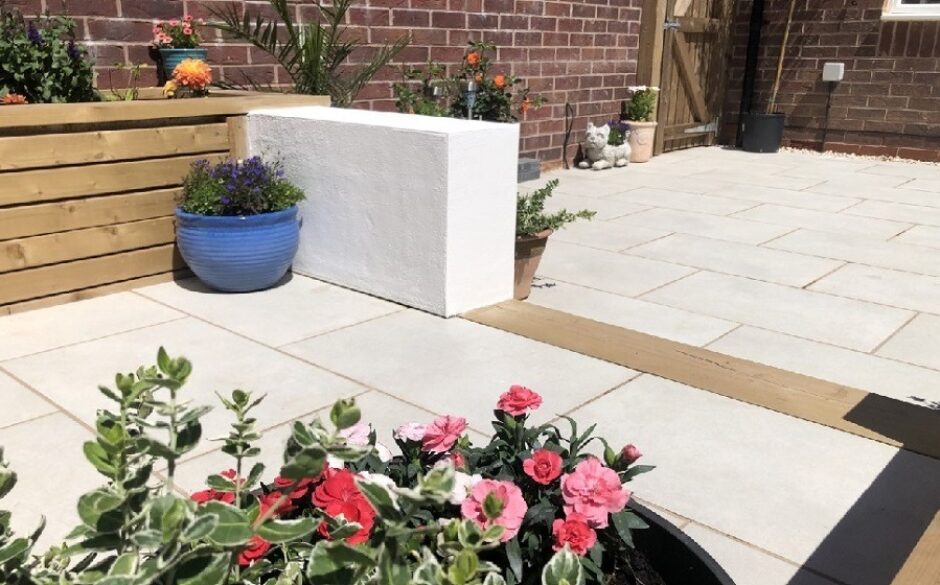 Customer garden with light patio tiles and beautiful pink flowers